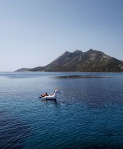 Man surfing in sea against clear sky