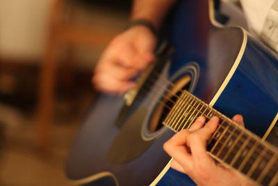 Cropped image of man plucking guitar