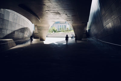 Rear view of silhouette man walking in tunnel