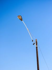 Low angle view of cables against clear blue sky