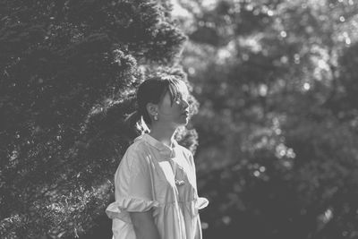 Thoughtful woman looking away in forest