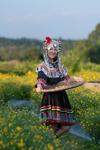 Woman with umbrella standing on field