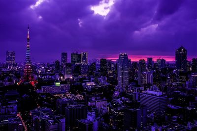 High angle view of illuminated tokyo tower by cityscape against cloudy sky at dusk