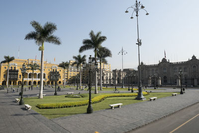 Panoramic view of people on street by buildings against sky