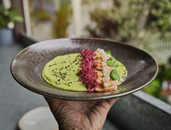 Close-up of savory japanese salmon tataki dish topped with sesame and served with crispy strips. 