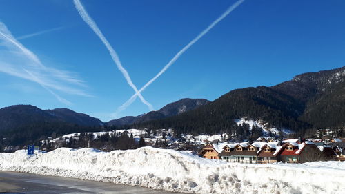 Panoramic view of buildings and mountains against blue sky