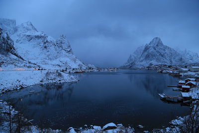 Scenic view of lake by snowcapped mountains against sky
