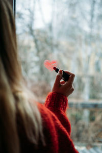 Close-up of hand holding red leaf