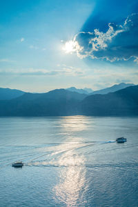 Scenic view of sea and mountains against sky