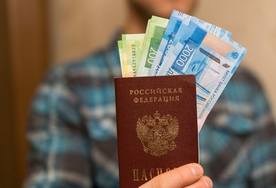 Midsection of man holding money and passport