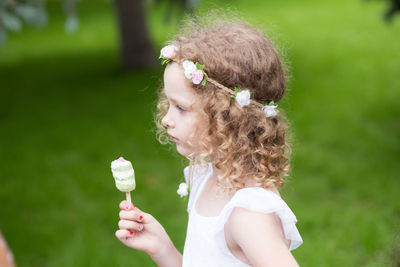 Girl wearing wreath while standing at public park