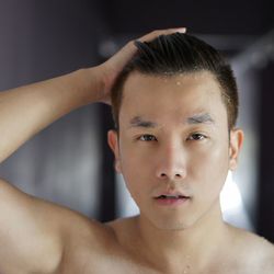 Close-up portrait of shirtless man with wet hair