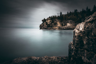 Rock formations by sea against sky