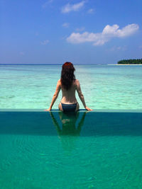 Rear view of woman standing on beach