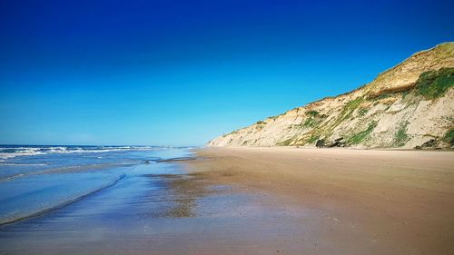 Scenic view of sea against clear blue sky