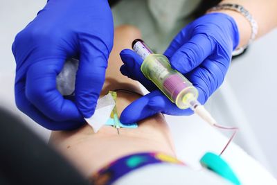 Cropped image of doctor giving iv drip to patient in hospital