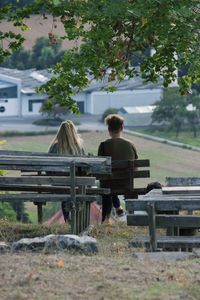 Rear view of people sitting on bench