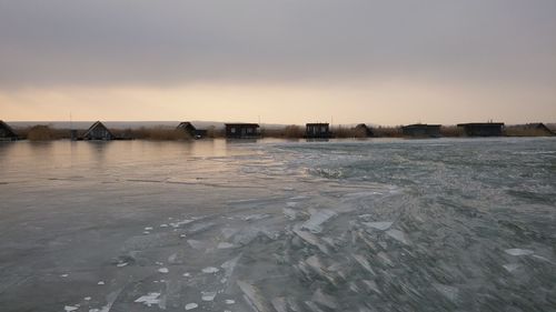 Scenic view of lake against sky during winter