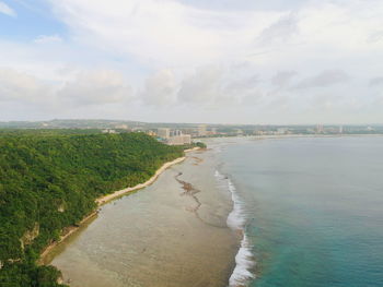 Aerial view of beach against cloudy sky