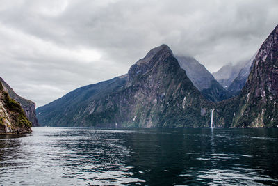 Scenic view of lake by mountains against sky