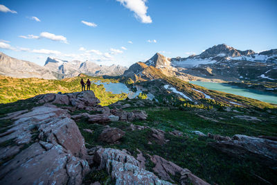 Couple holding hands during sunset surrounded by mountains in rockies