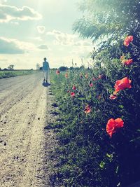 Man walking on field against sky