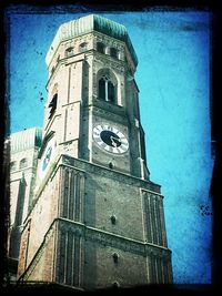 Low angle view of clock tower against blue sky