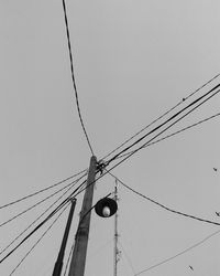 Low angle view of power lines against clear sky