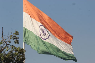 Low angle view of flag against clear blue sky