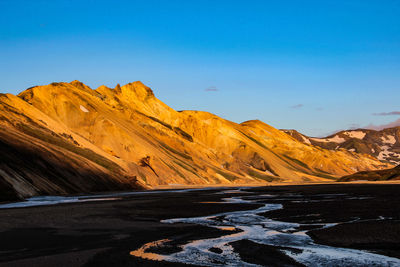 Scenic view of mountains against clear blue sky