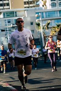 People running on road in city