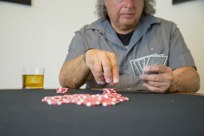 Man playing poker while sitting at table