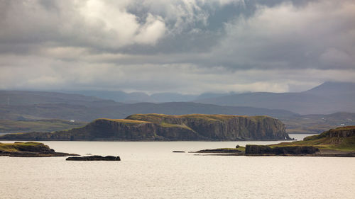 Scenic view of sea and mountains against sky