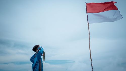 Low angle view of woman standing against sky