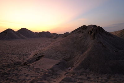 Scenic view of desert against sky during sunset