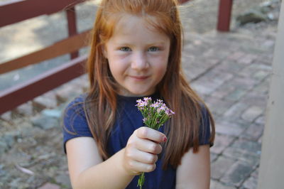Portrait of a smiling girl holding flower