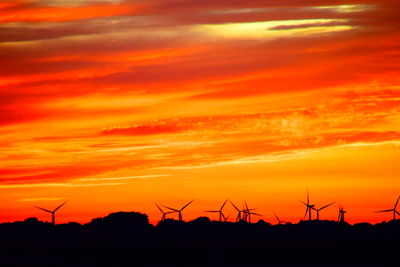 Silhouette of wind turbines at sunset