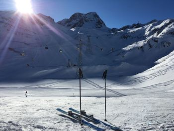 Scenic view of snow covered mountains against bright sun