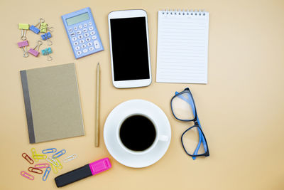 Directly above shot of various objects over yellow background