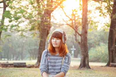 Portrait of beautiful young woman against trees