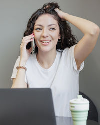 Young woman using mobile phone while sitting at home