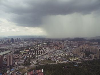 Aerial view of cityscape against storm clouds