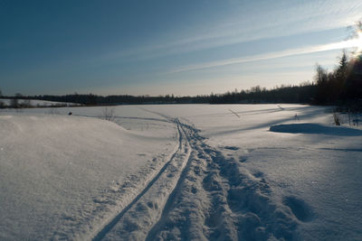 Scenic view of snow covered field against sky