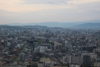 Aerial view of buildings in city against sky