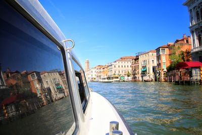 Boats in city against clear blue sky