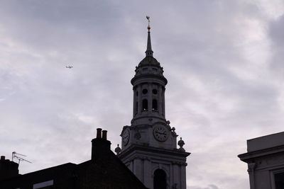 Low angle view of building against cloudy sky