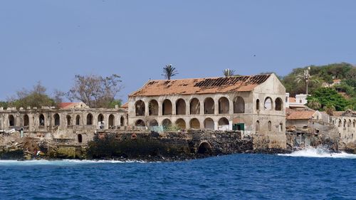 Castle by river against clear blue sky