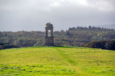 Built structure on field against sky