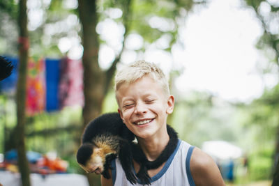 Smiling boy with money sitting on shoulder