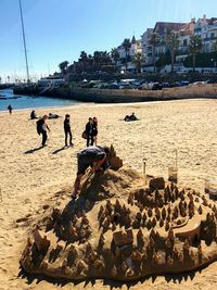 People on beach against clear sky